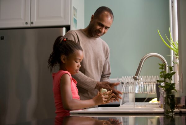 father and daughter washing hands at the sink