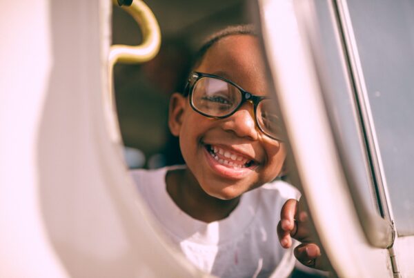 small boy smiling and wearing glasses