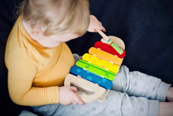 kid playing with toy xylophone