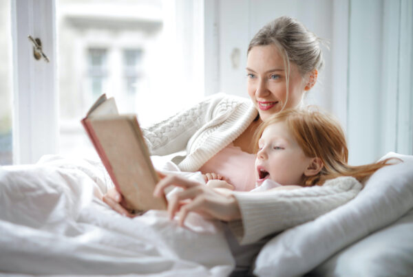 mom and daughter reading in bed