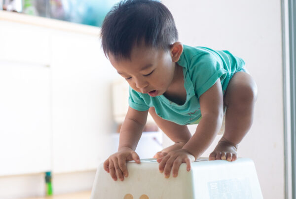 small child uses stool to climb