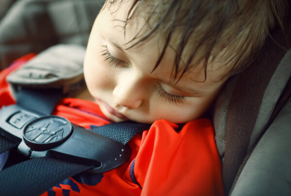 little boy sleeping in car seat